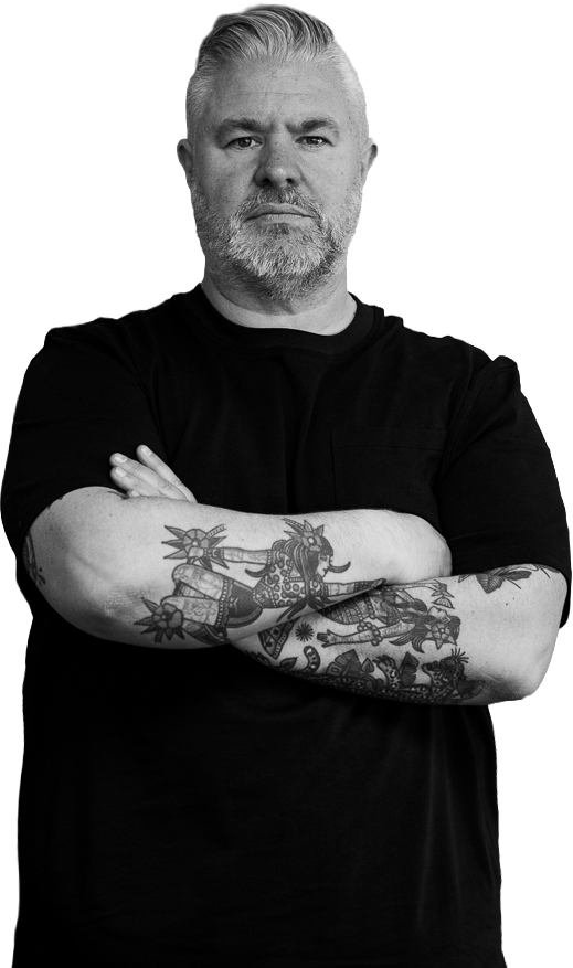Matt Thomas, brand and positioning strategist, standing with arms crossed in a black T-shirt