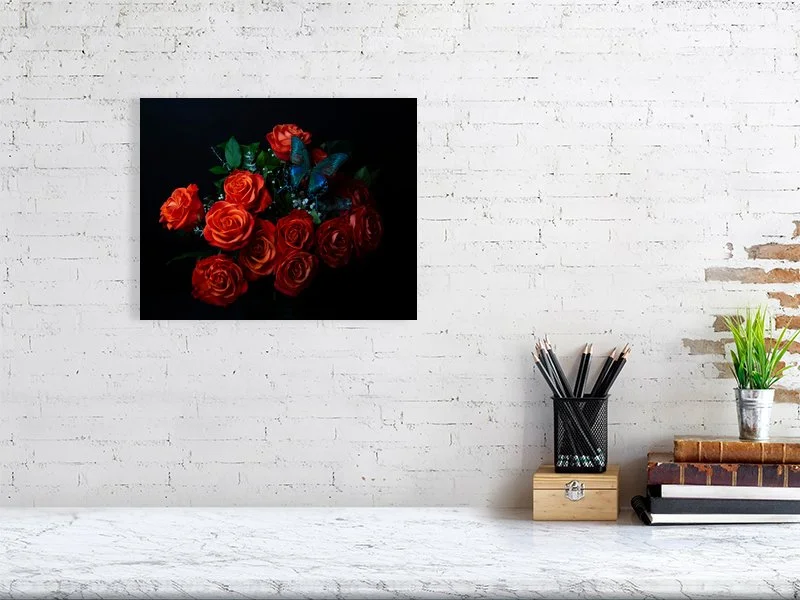 Fine art photograph of an iridescent blue butterfly perched on a bouquet of orange roses for sale sample of home decor.