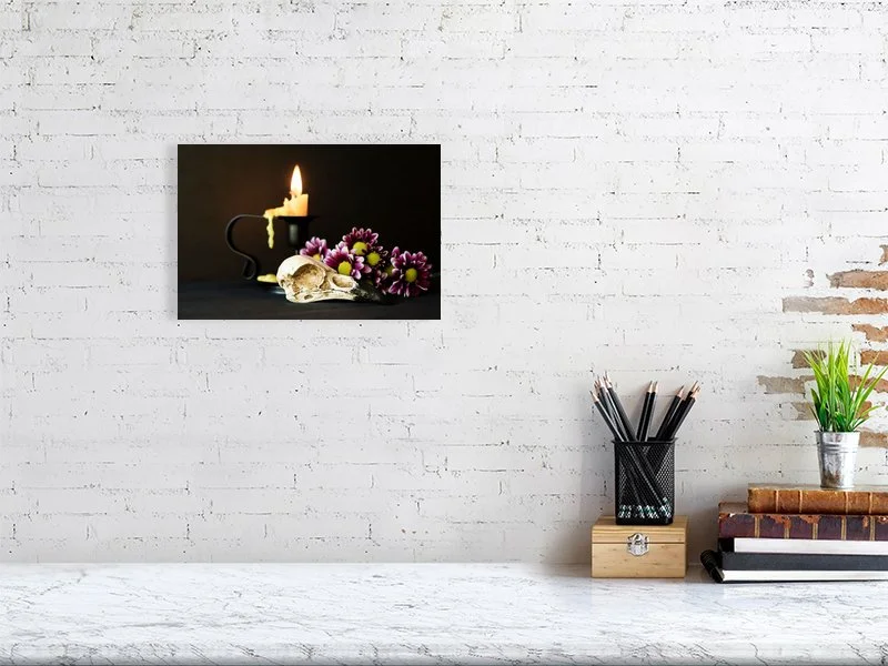 Fine art image of a Raven Skull with Yellow Candle and Purple Daisies on a dark background. For sale, art prints, photograph, home decor, gifts.