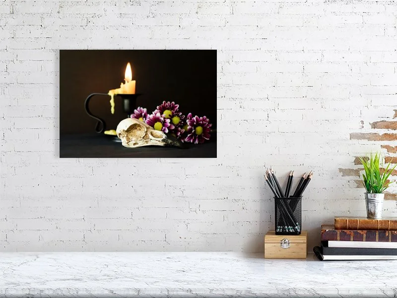 Fine art image of a Raven Skull with Yellow Candle and Purple Daisies on a dark background. For sale, art prints, photograph, home decor, gifts.