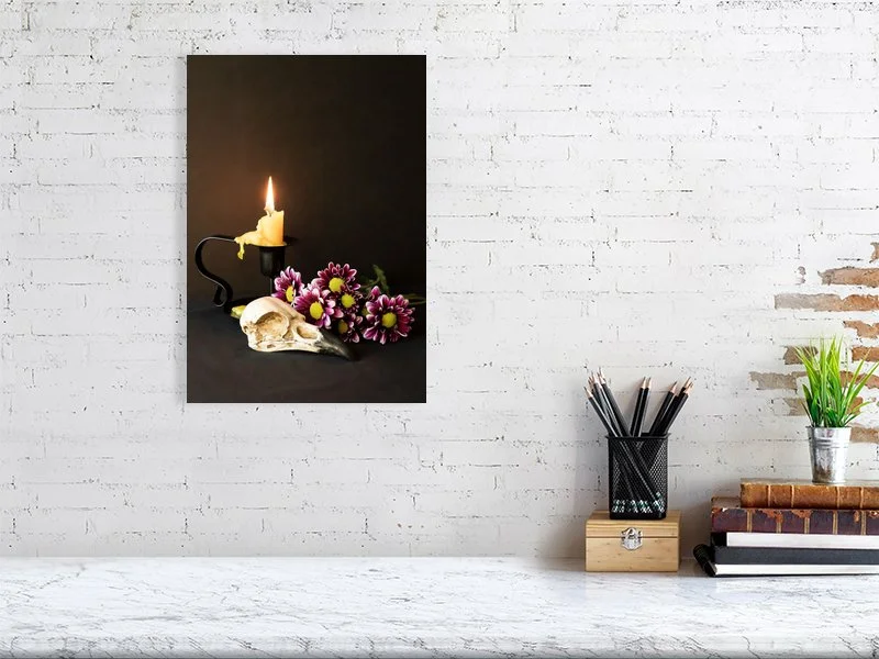 Fine art image of a Raven Skull with Yellow Candle and Purple Daisies on a dark background. For sale, art prints, photograph, home decor, gifts.