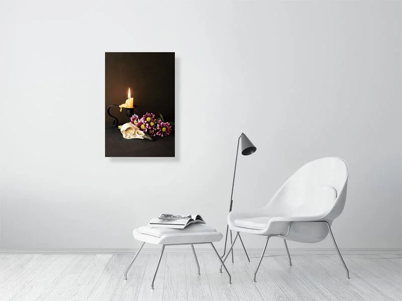 Fine art image of a Raven Skull with Yellow Candle and Purple Daisies on a dark background. For sale, art prints, photograph, home decor, gifts.
