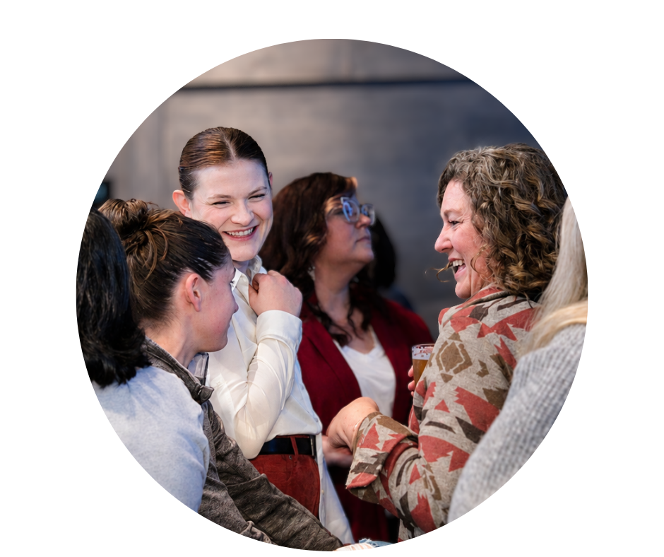 Group of women talking and laughing at a social gathering.
