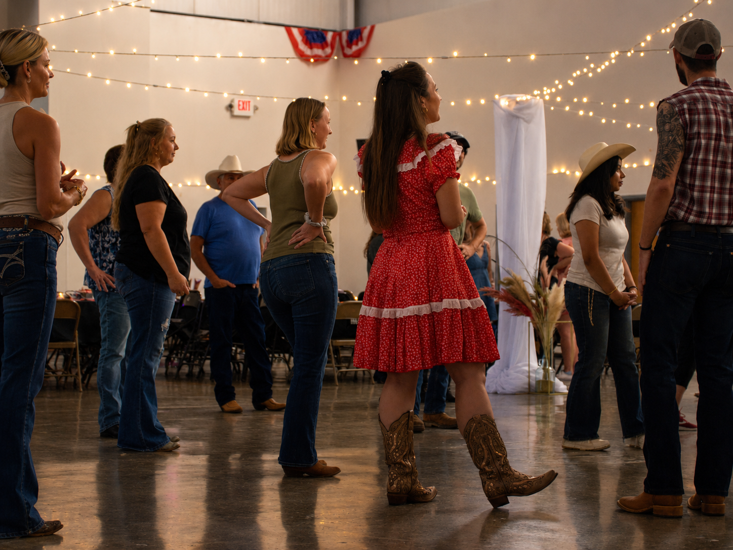 People line dance at a country-themed event decorated with string lights and patriotic bunting.
