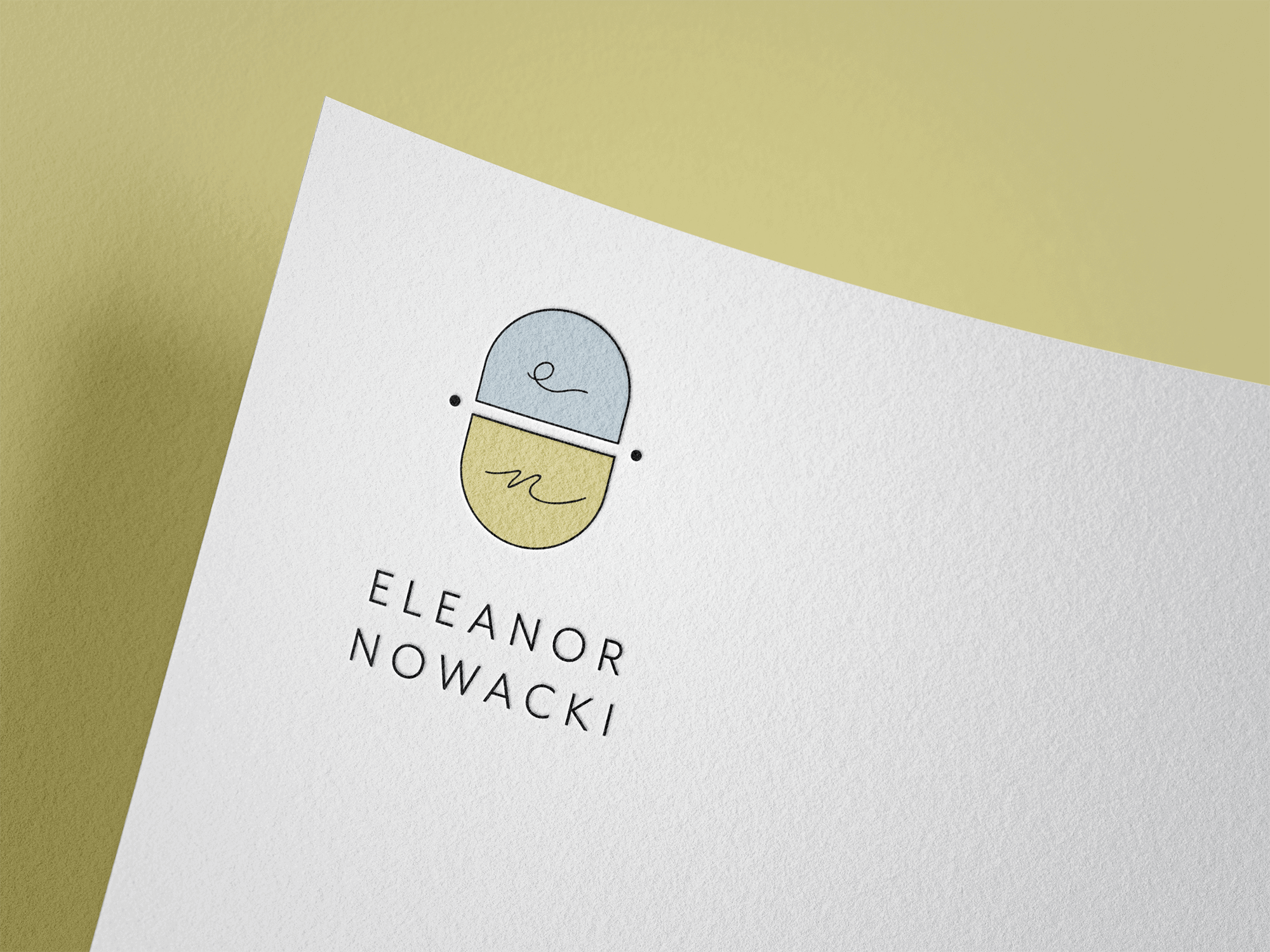 A white sheet of paper features a minimalist logo comprising two overlapping capsules, one light blue and one light yellow, with simple line drawings inside. Below the logo, the name "Eleanor Nowacki" is printed in uppercase black letters.