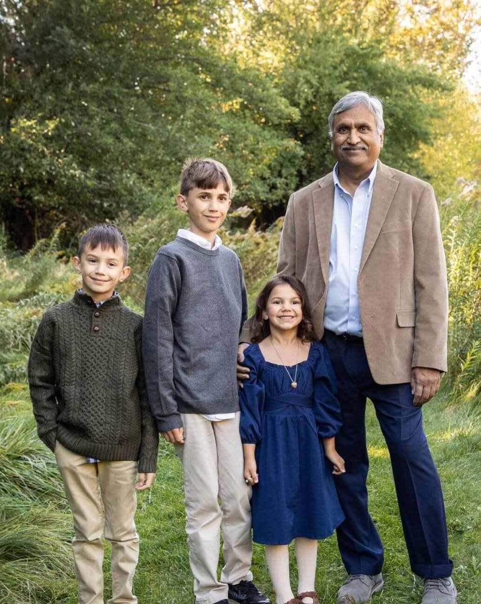 Rakesh Mohan and his 3 young grandchildren posing in a nature setting