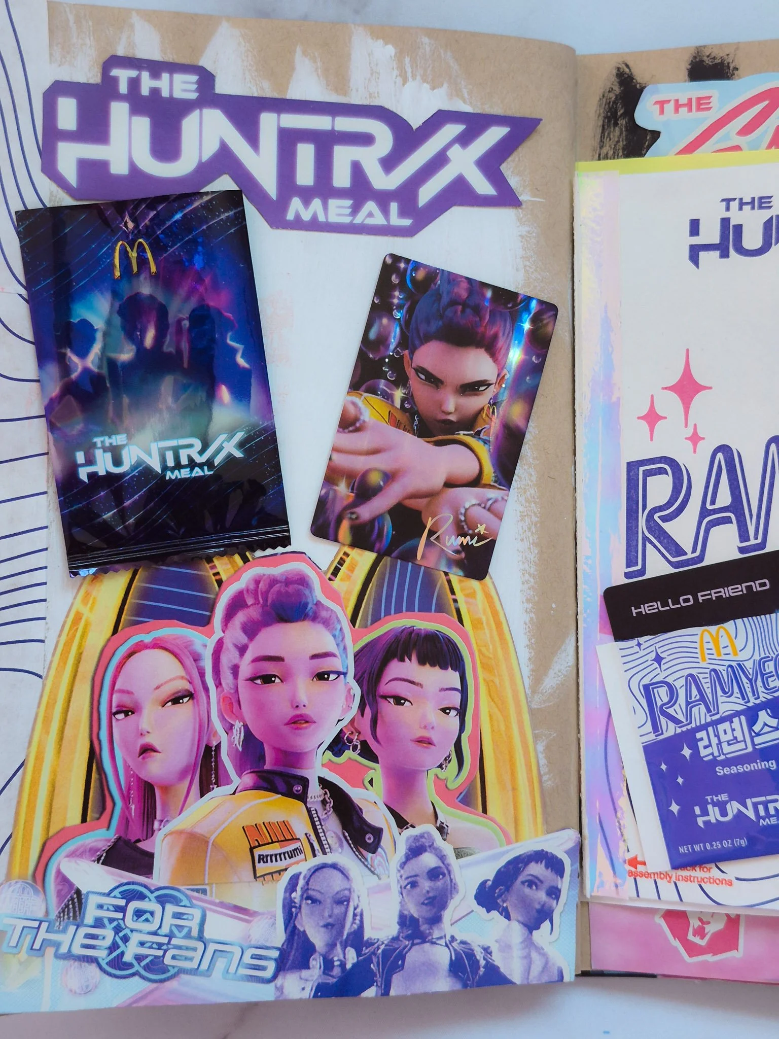 a junk journal spread of the McDonald's + K Pop Demon Hunters collab with iridescent accents and washi tape