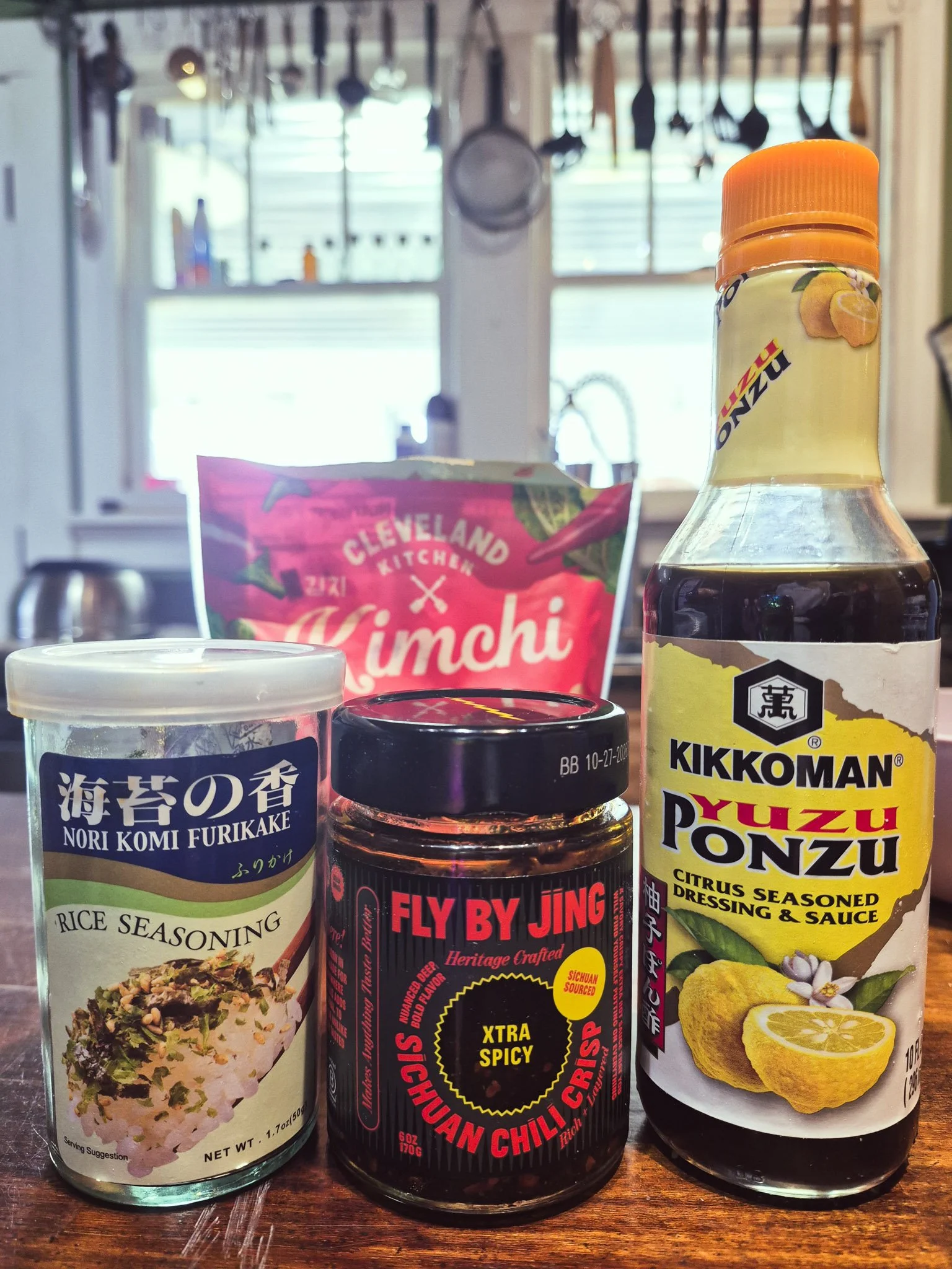 close up image of a group of condiments - nori furikake, chili crisp, ponzu, and kimchi