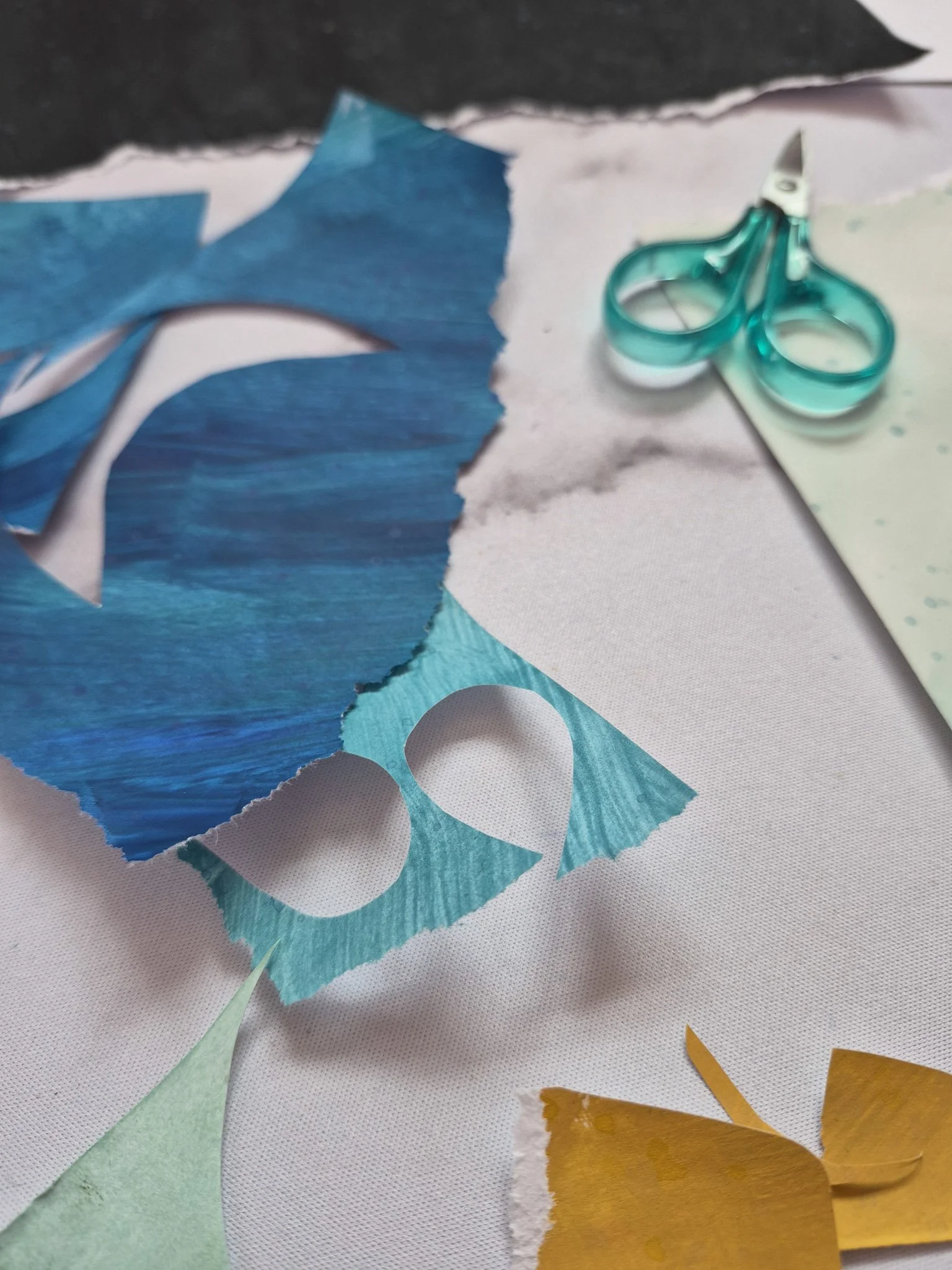 workspace shot with cut paper scraps and a pair of sharp scissors
