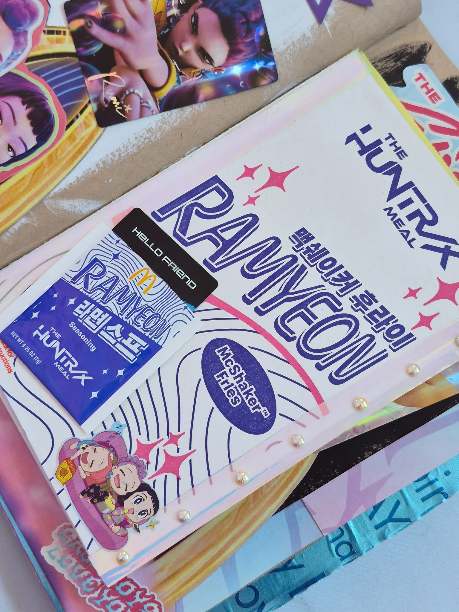 a junk journal spread of the McDonald's + K Pop Demon Hunters collab with iridescent accents and washi tape