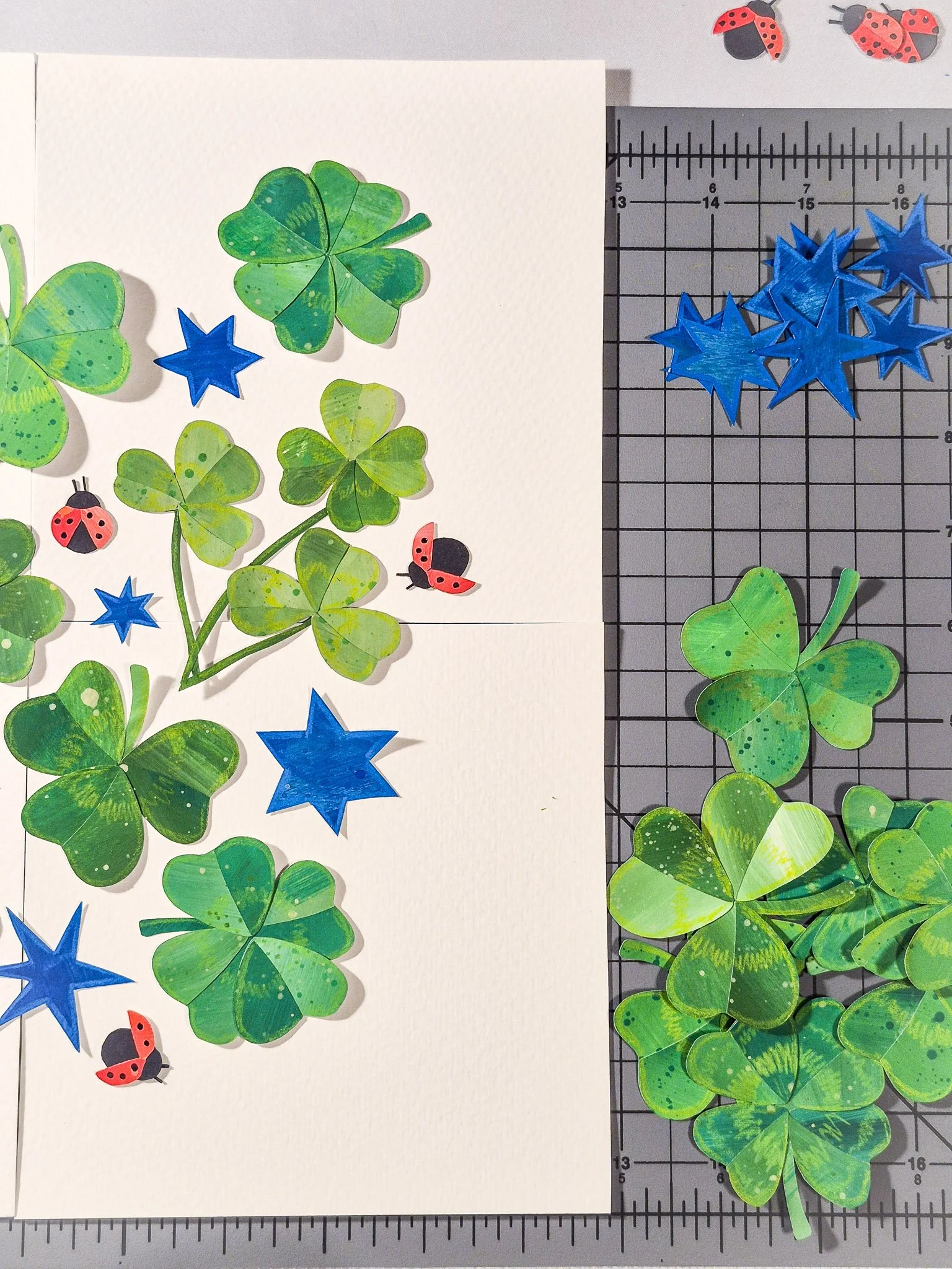 Handmade collage elements arranged on paper to begin forming a repeat pattern composition