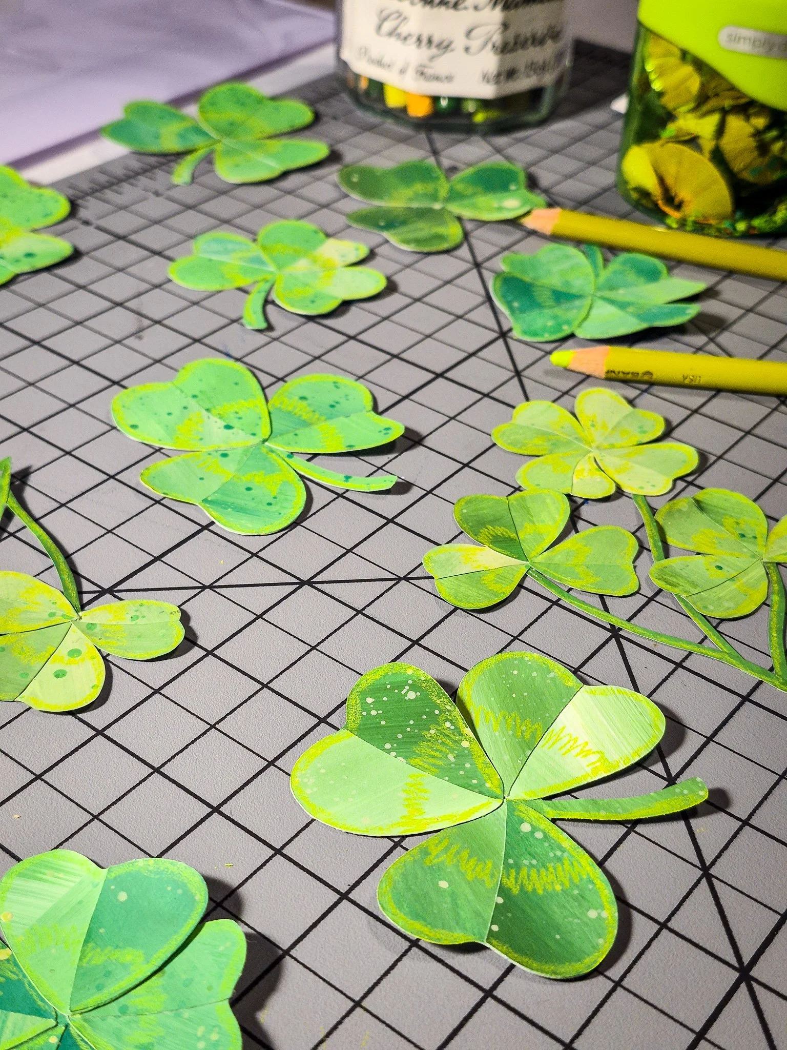 Close-up of painted clover collage pieces with added pencil and paint details for texture in an analog pattern design