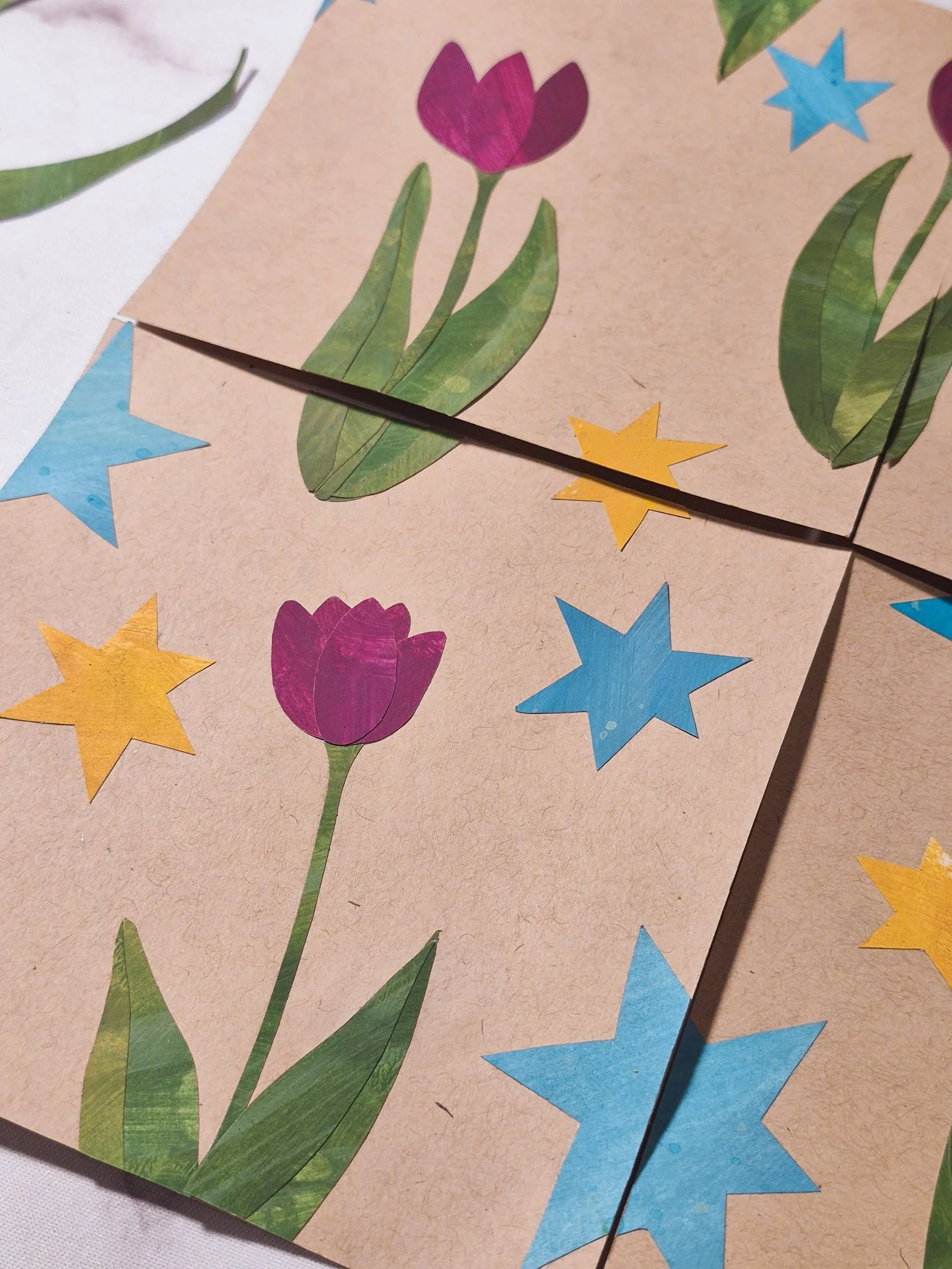 A closeup finished analog repeat pattern created with hand-cut paper collage pieces arranged into a seamless design