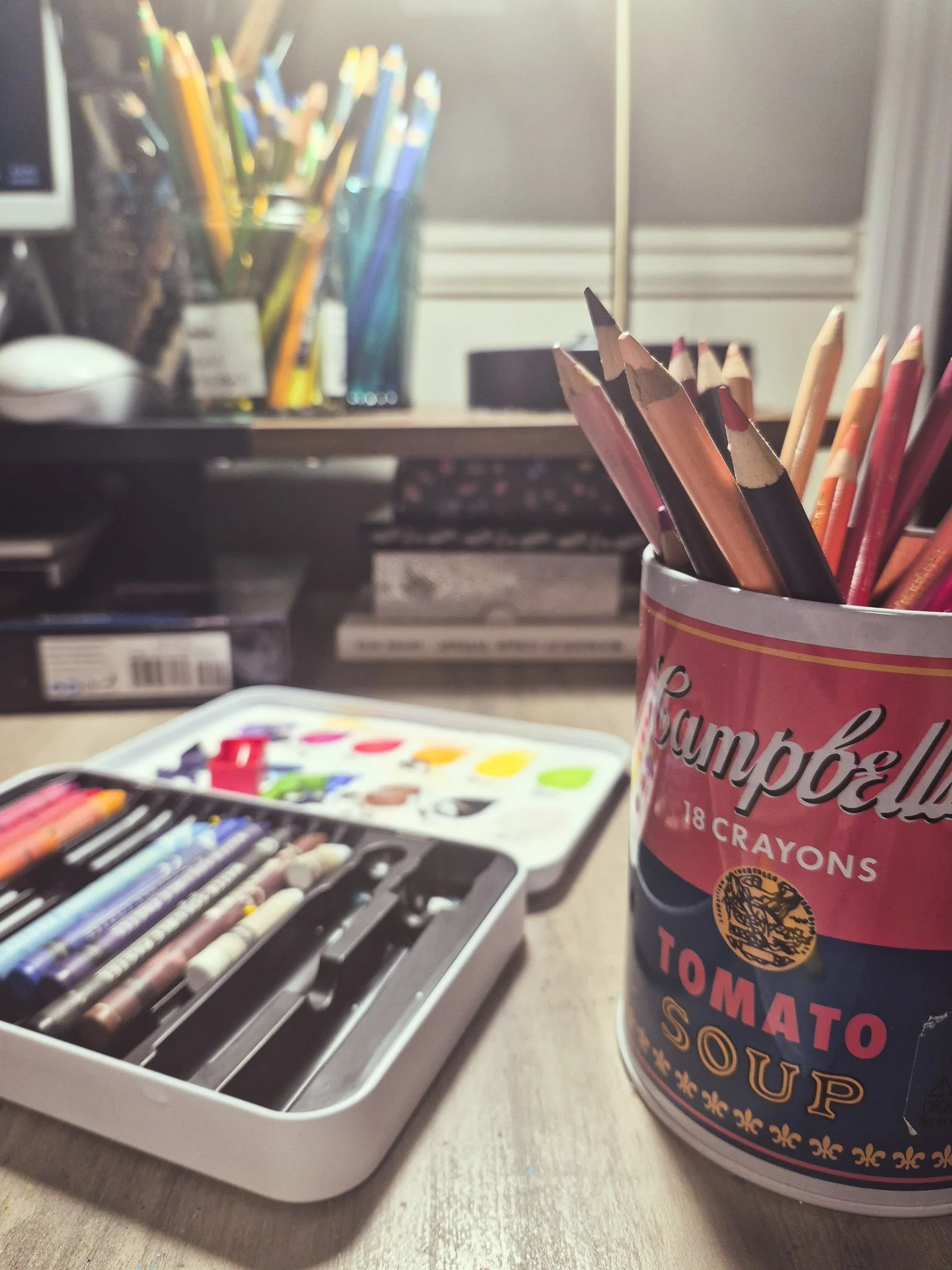a close up desktop photo with colored pencils contained in empty jam jars
