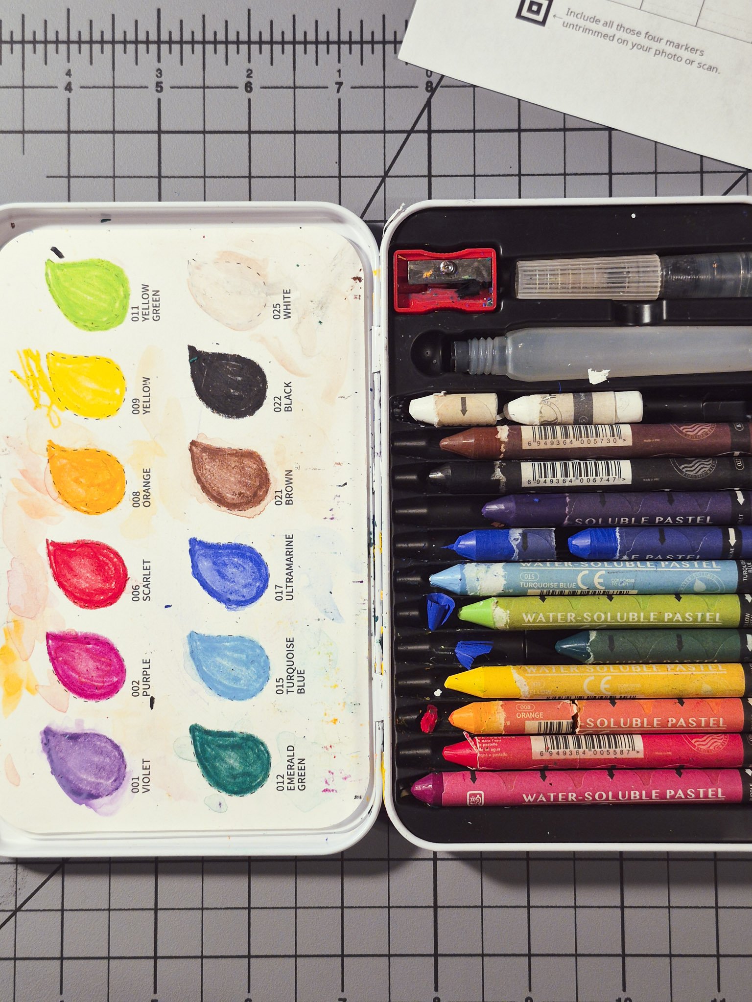 Used watercolor pastel set with color swatches and textured paint buildup in tin