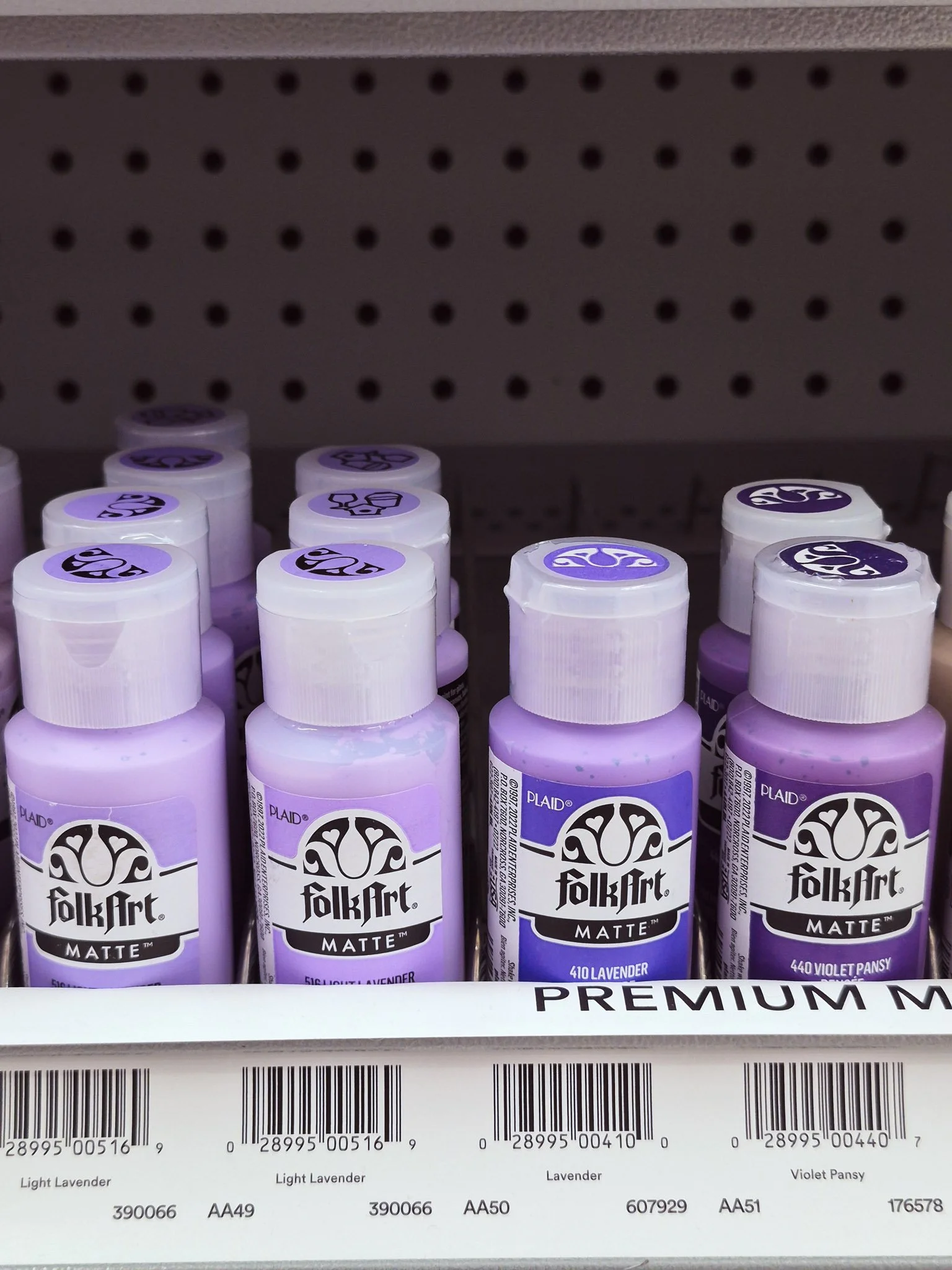 Shelf of lavender and violet acrylic paint bottles during a color inspiration hunt at a craft store