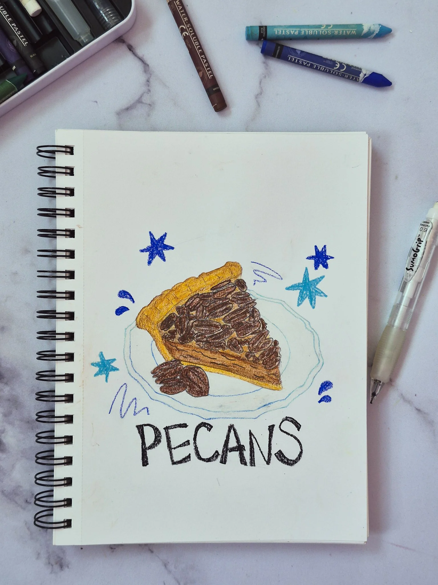 overhead image of a sketchbook with illustration of a slice of pecan pie