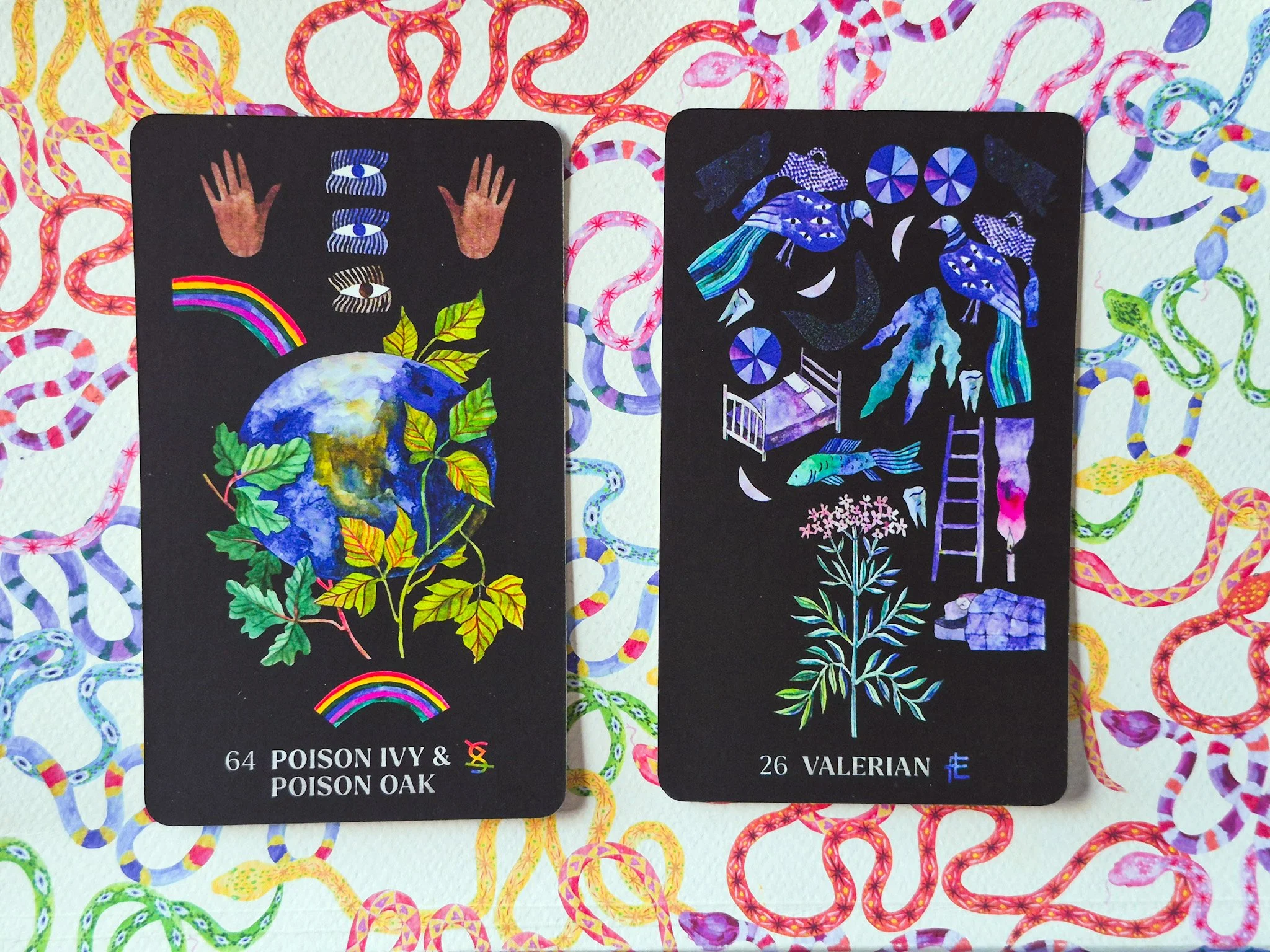 flat lay of Dirt Gems tarot cards on top of a notebook with a colorful rainbow snake pattern on it