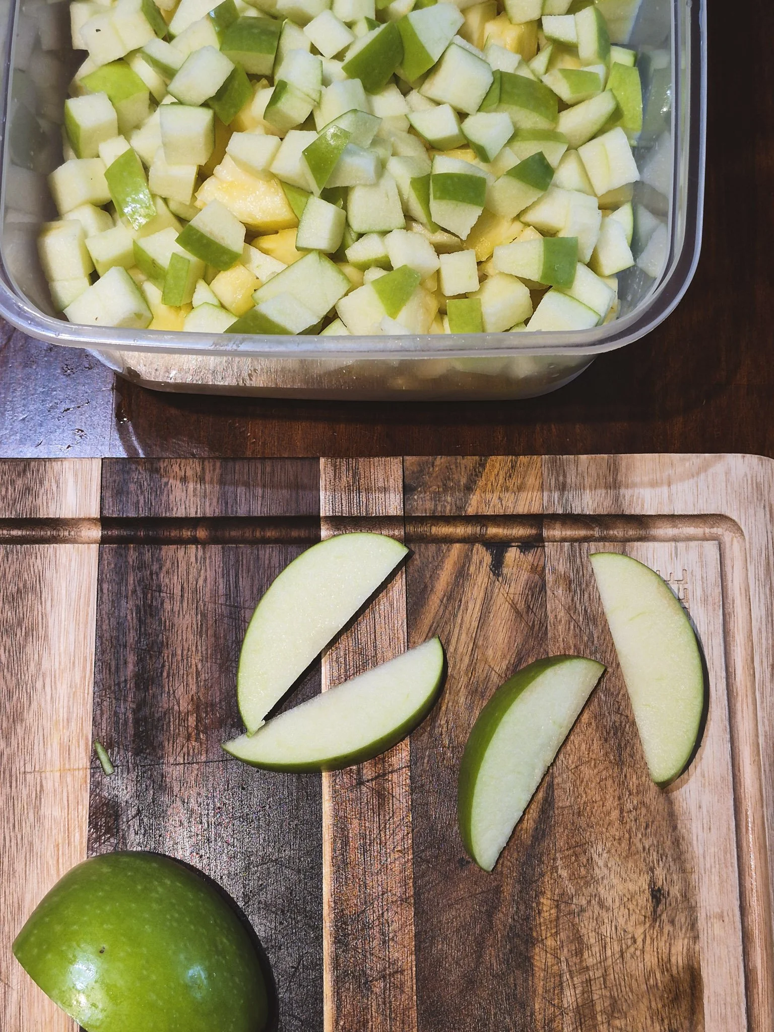 kitchen prep for pineapple + apple salad with chopped green apples on a wooden cutting board