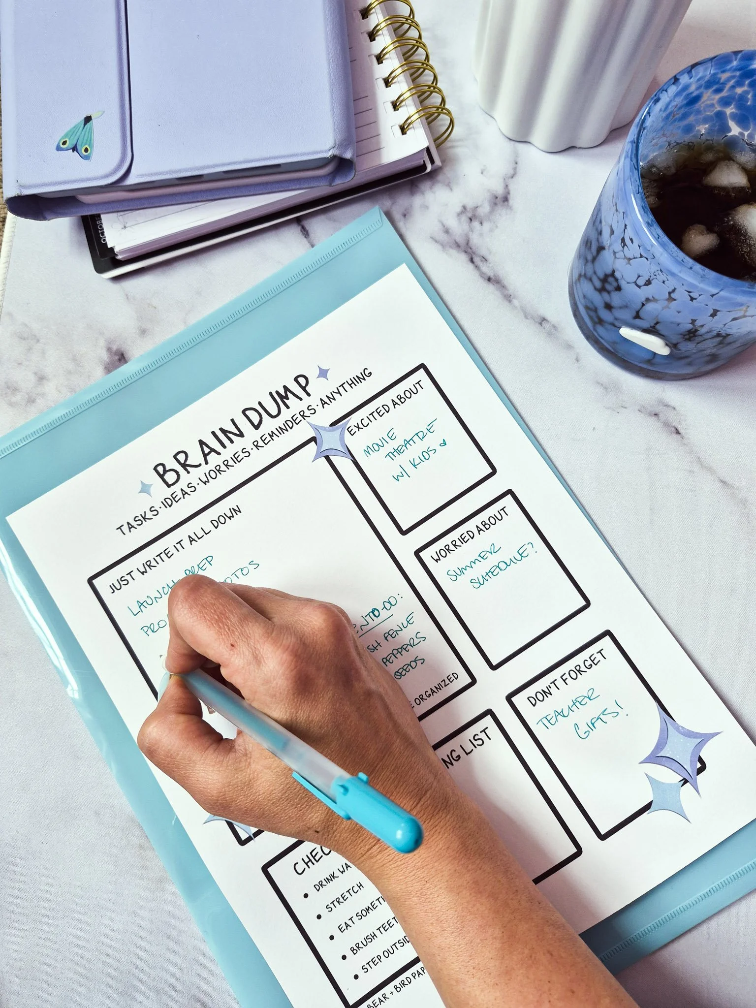 Hand writing on a brain dump printable sheet with sections for tasks, worries, and reminders using a teal pen