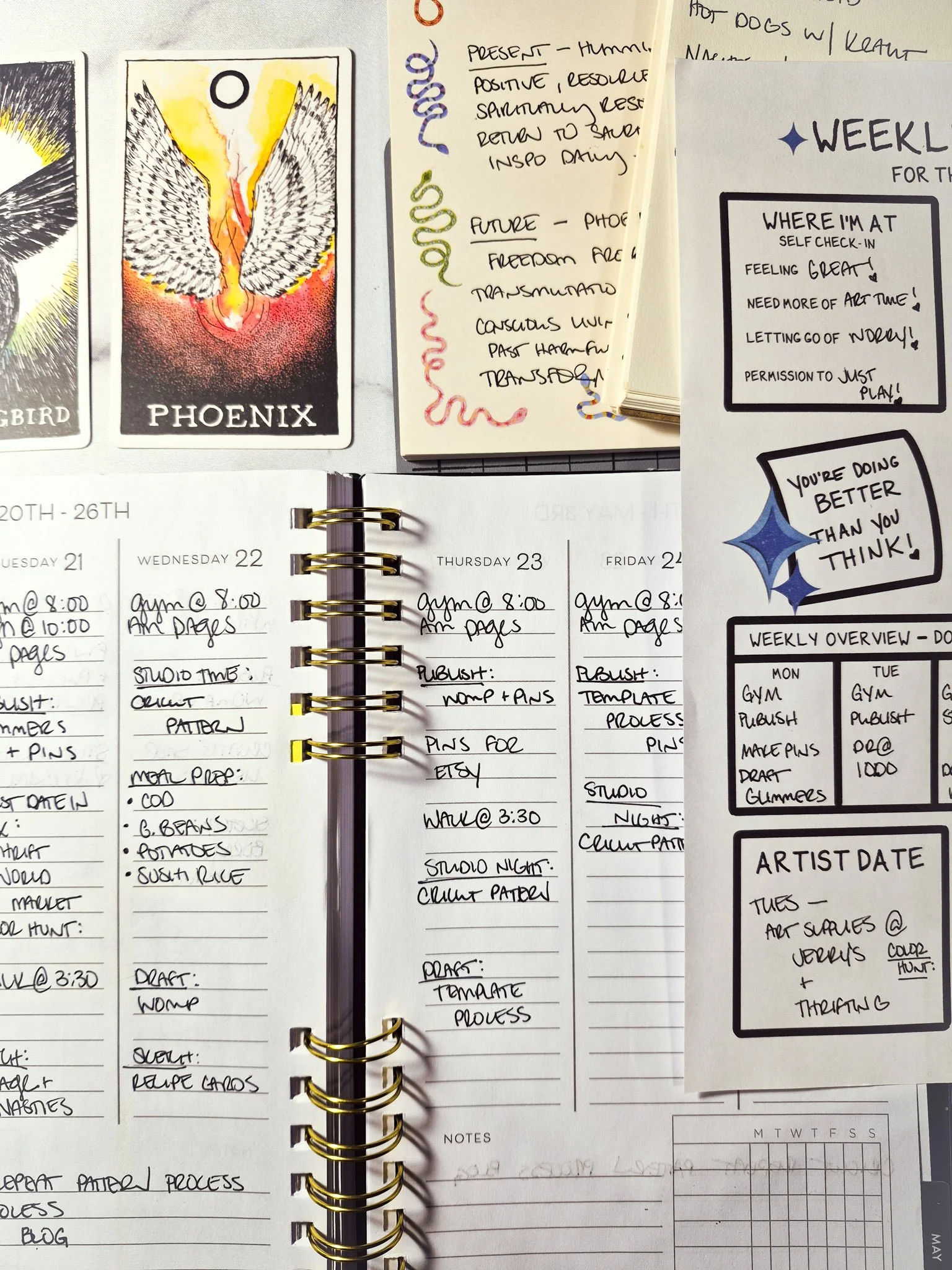 Weekly planner spread paired with a creative reset worksheet showing handwritten schedule, studio time, and content planning tasks