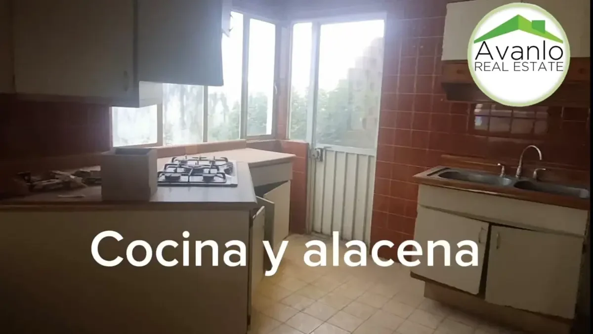 Cocina con estufa, fregadero, ventanas grandes y área de almacenamiento