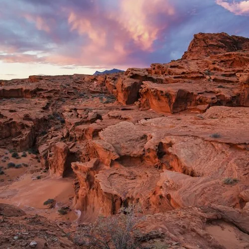expansive red rock formations with pink clouds above