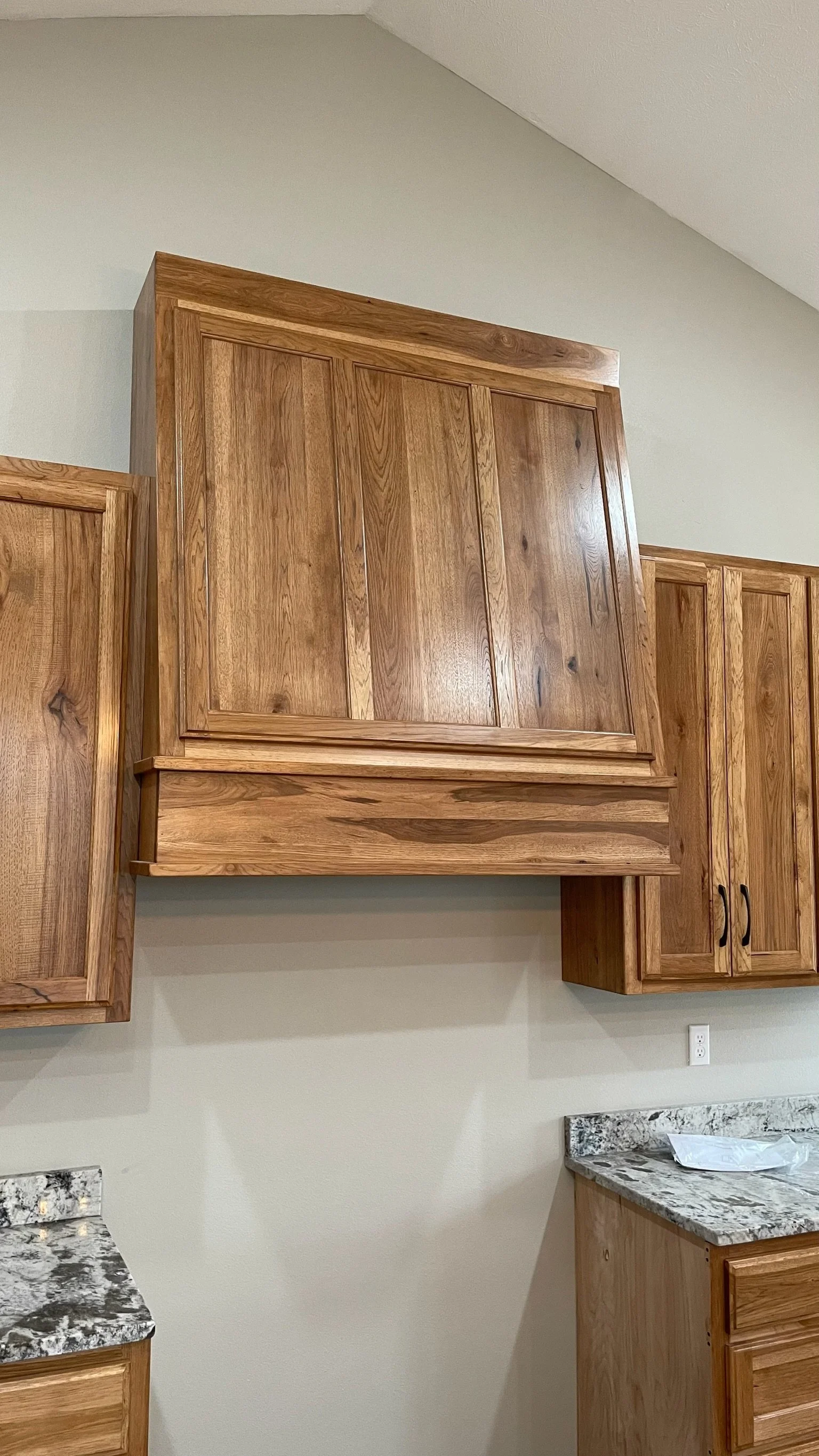 Wooden kitchen cabinets with a granite countertop below.