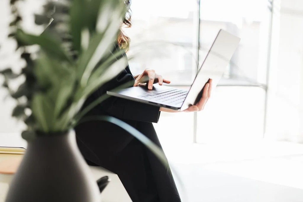 Photo of woman in black dress holding laptop