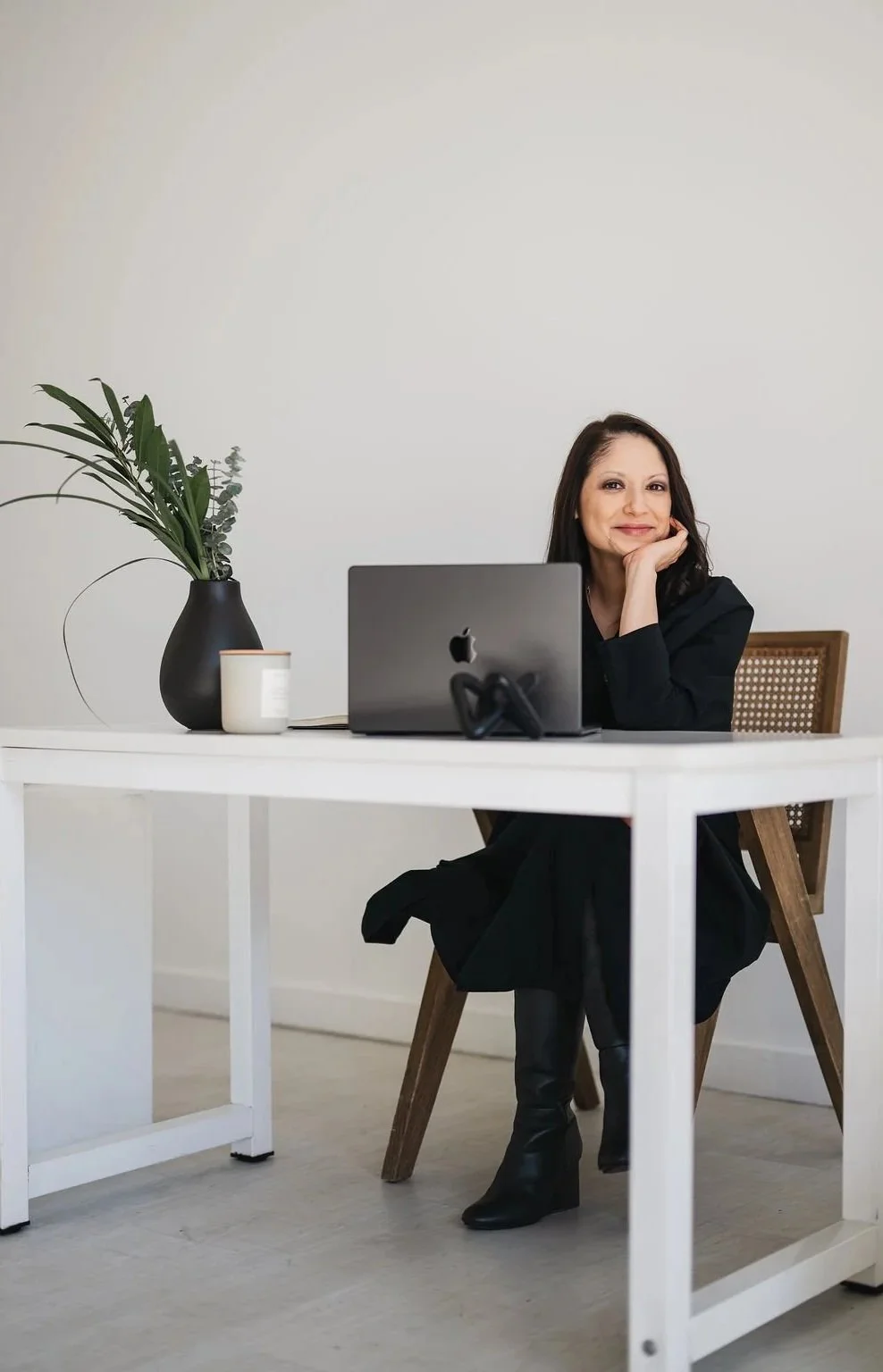 Photo of woman smiling at her desk with gray laptop