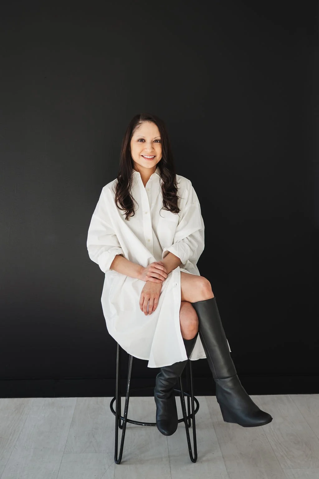 Photo of woman with white dress with black background on a stool