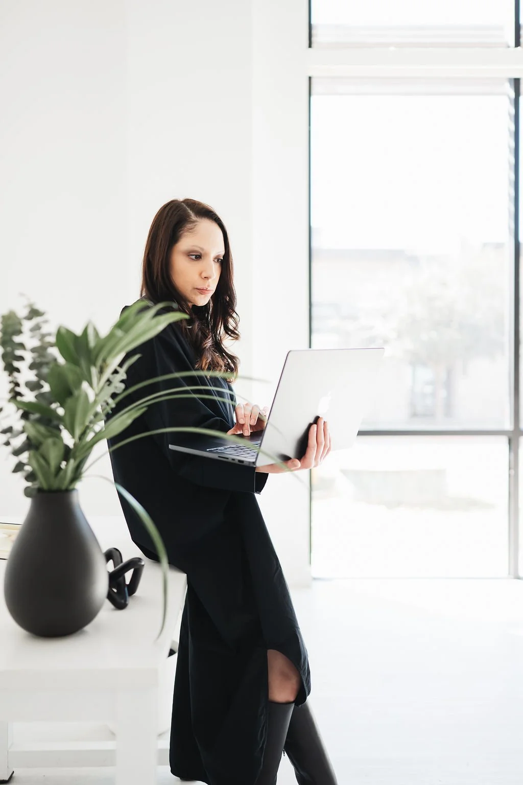 Photo of woman with black dress holding laptop