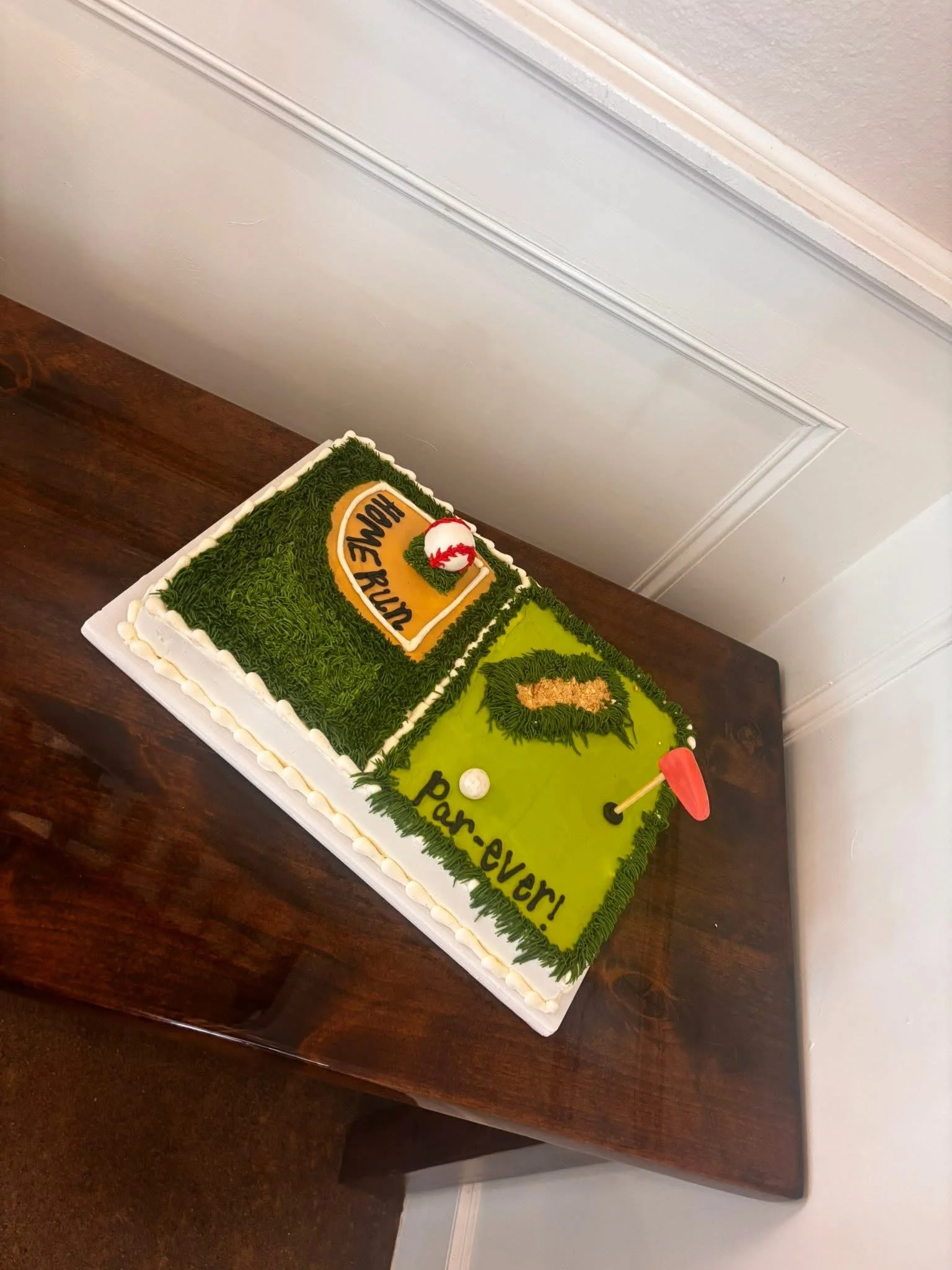 A cake decorated like a golf course with a green playing field, a flag, and a golf ball, featuring a logo and the words "Par-evori".