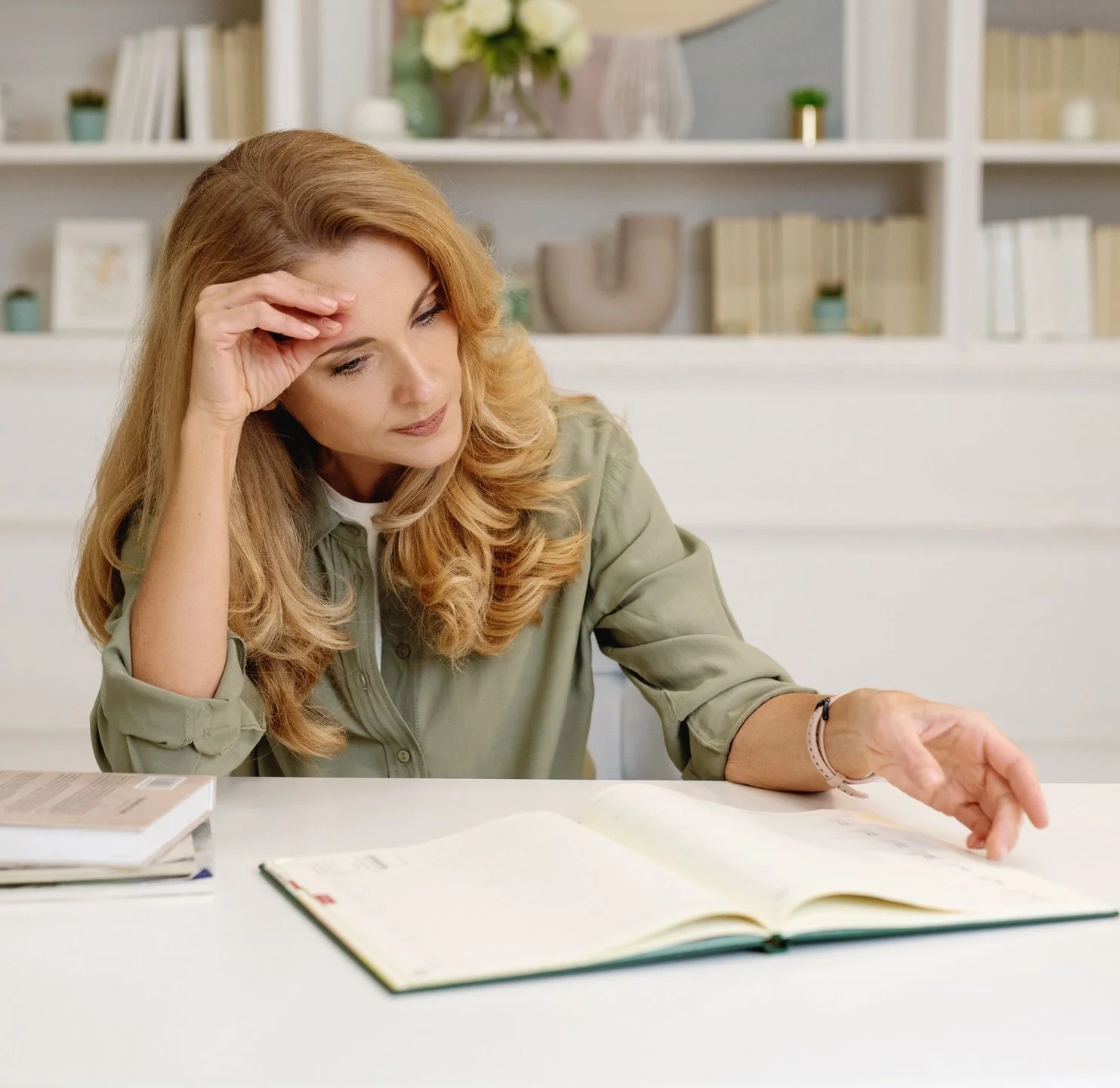Woman at a desk looking at a notebook