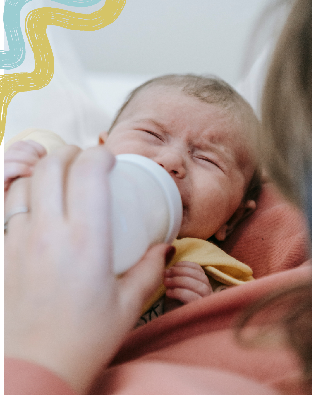 A baby is being fed with a bottle by an adult, likely a parent, with a close-up view of the baby's face showing it crying or fussing, while the adult's hand holds the bottle.