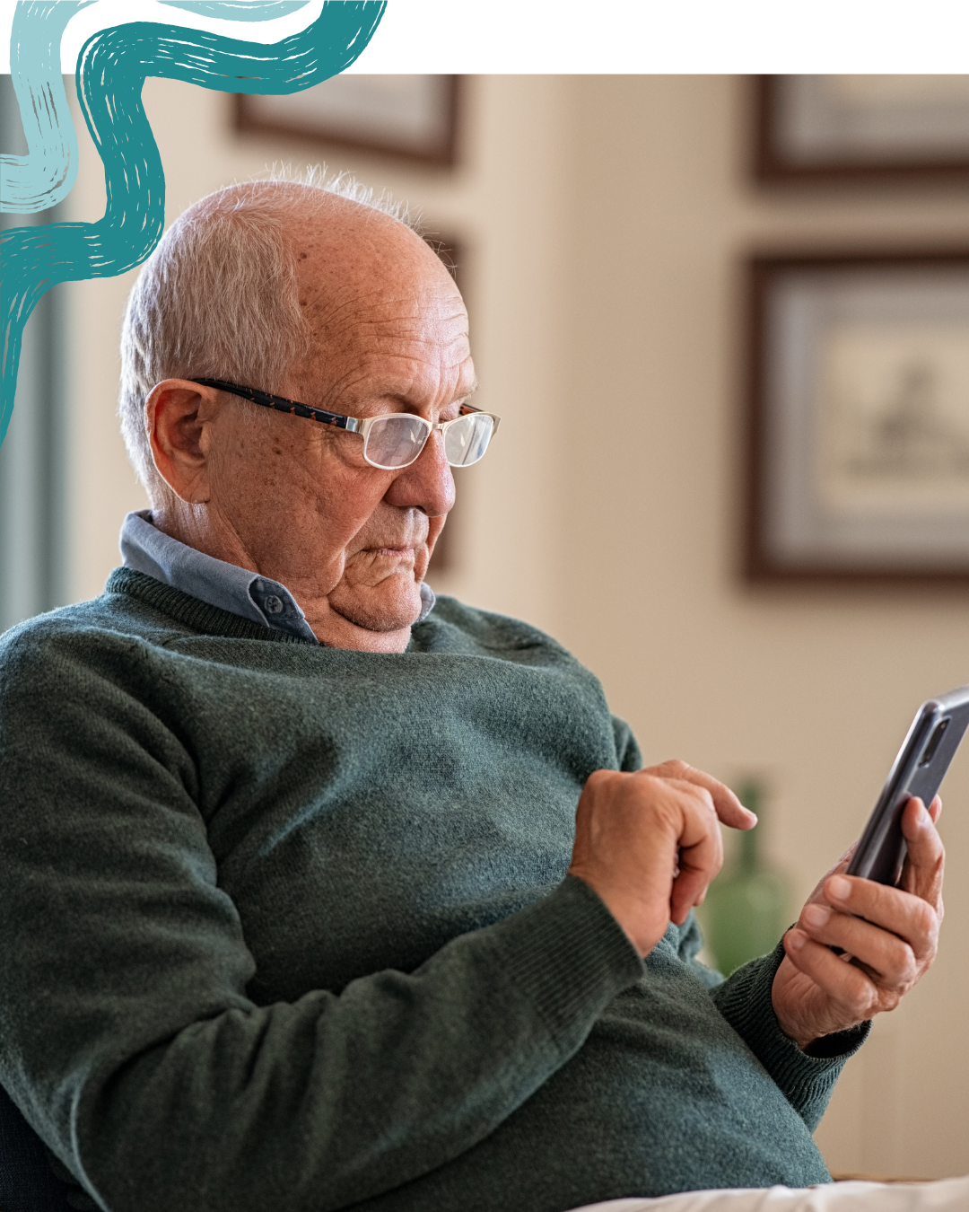 An elderly man with glasses looking at a smartphone in a living room.