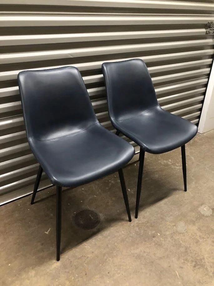 Front view of navy blue faux leather dining chair with black metal legs