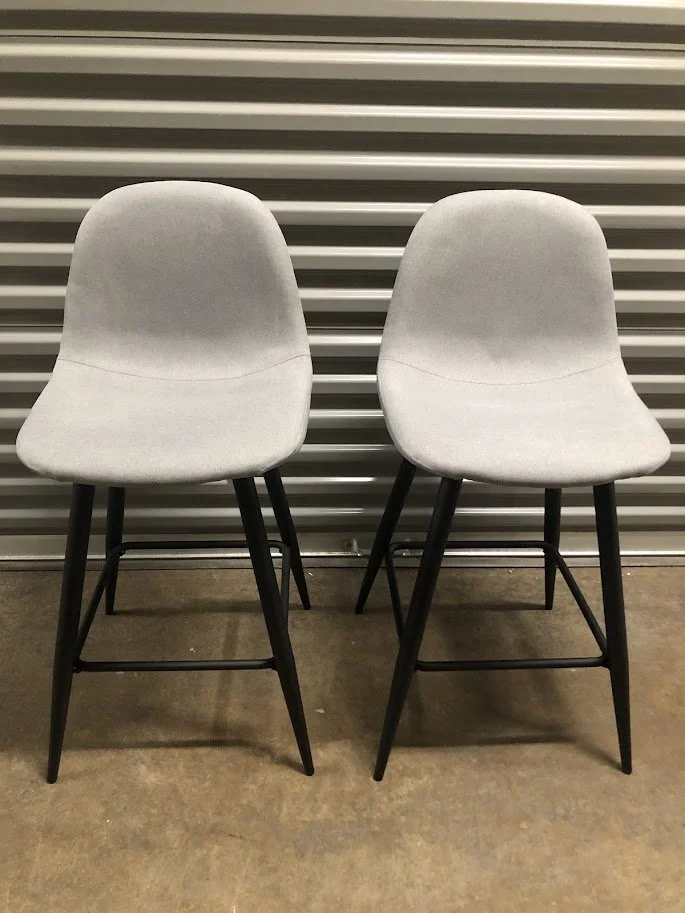 LumiSource Pebble 24 inch light grey fabric and black metal counter stools set of 2