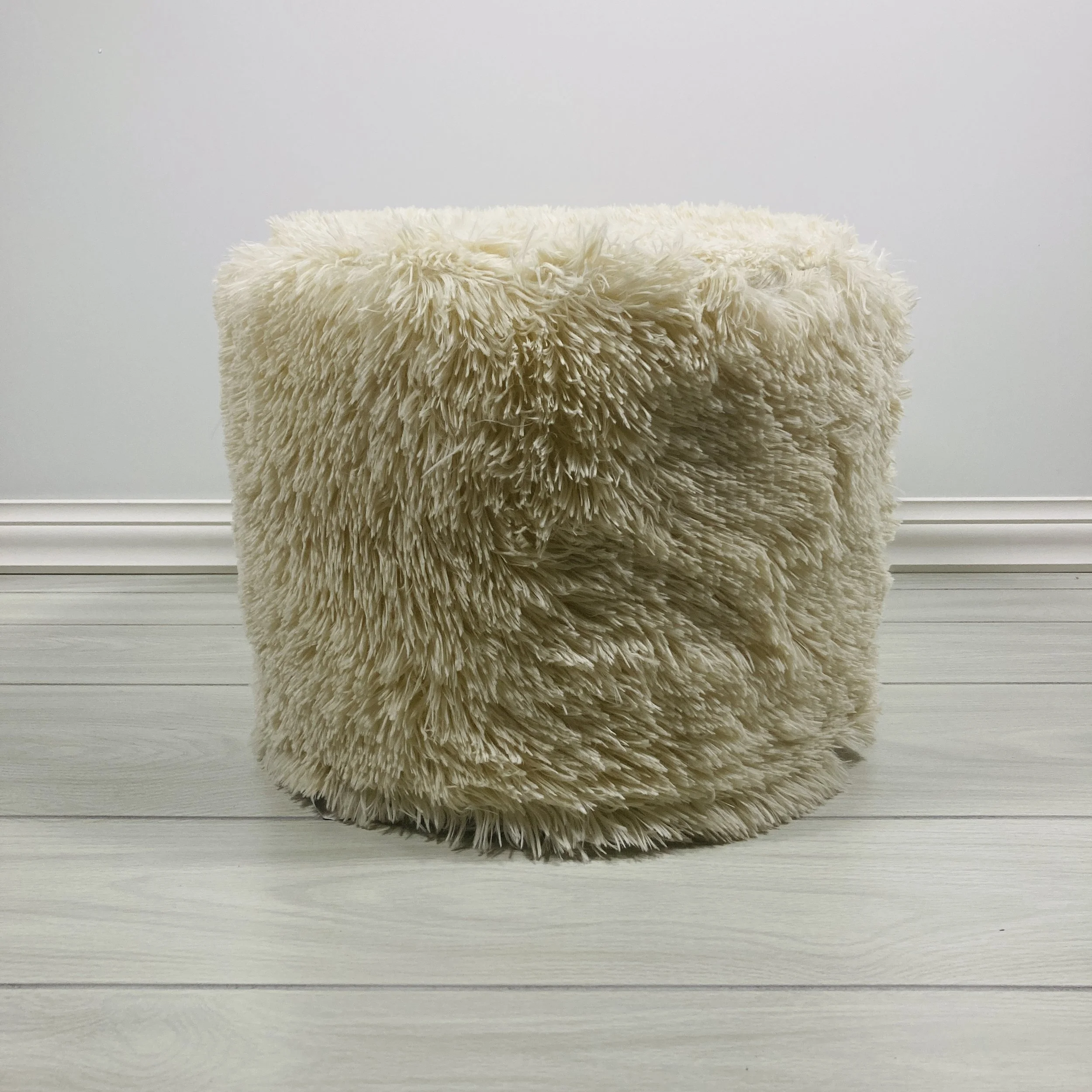 BEIGE-FAUX-FUR-UPHOLSTERED-ROUND-POUF-SIDE-VIEW.JPG