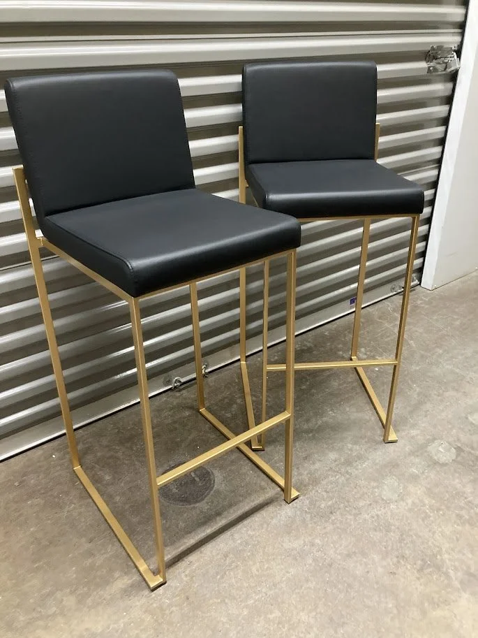 Side profile of 30 inch black faux leather bar stool with gold metal legs