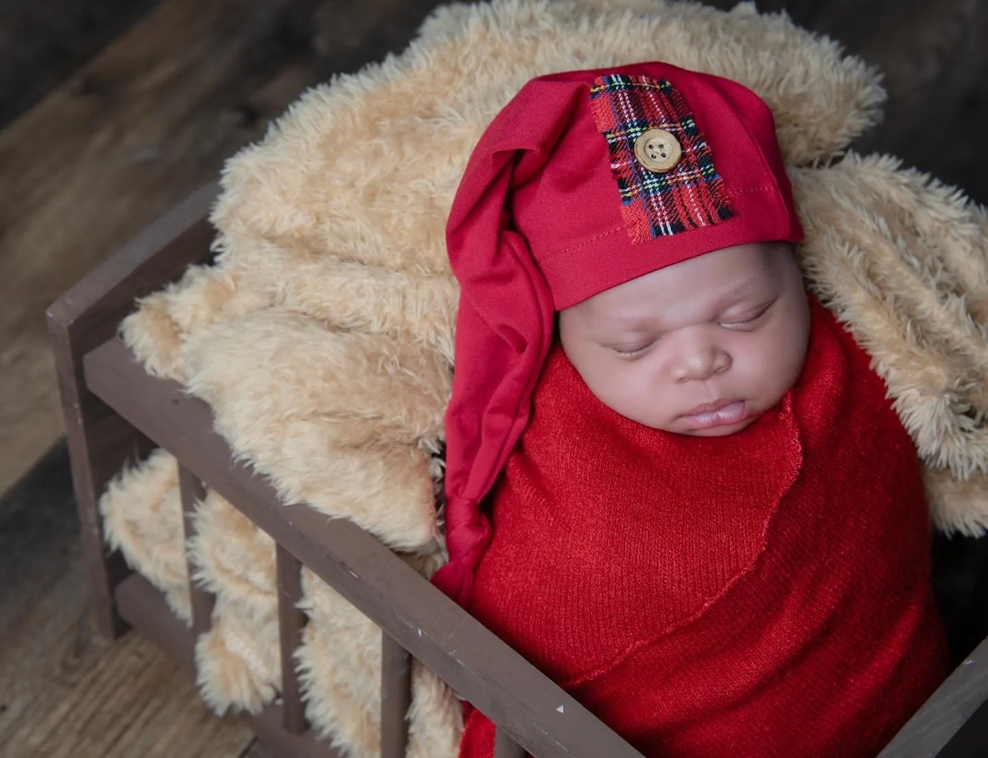 Newborn baby boy wrapped in red fabric 
