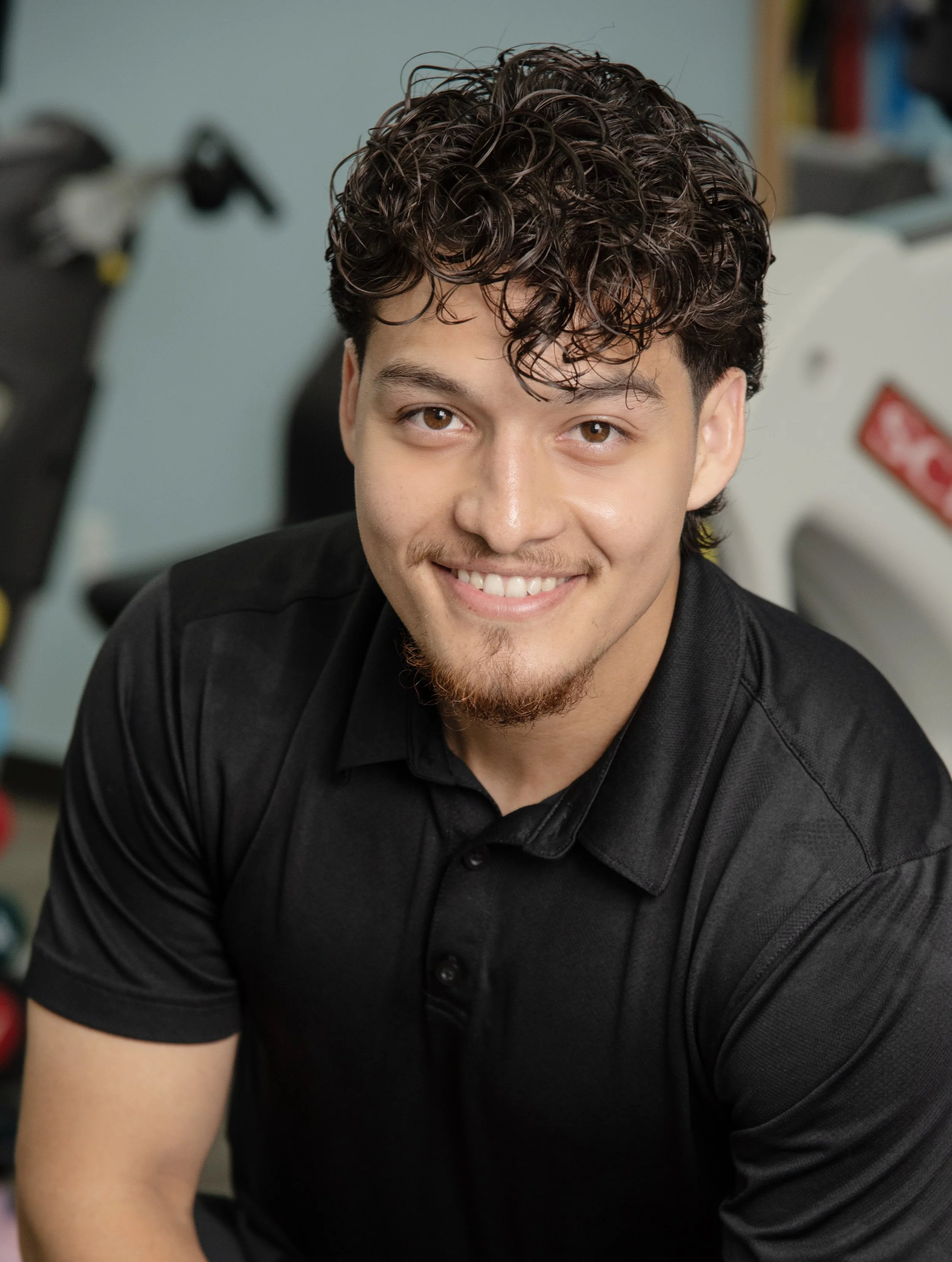 A male physical therapist at Results Physiotherapy for branding headshot in black shirt.