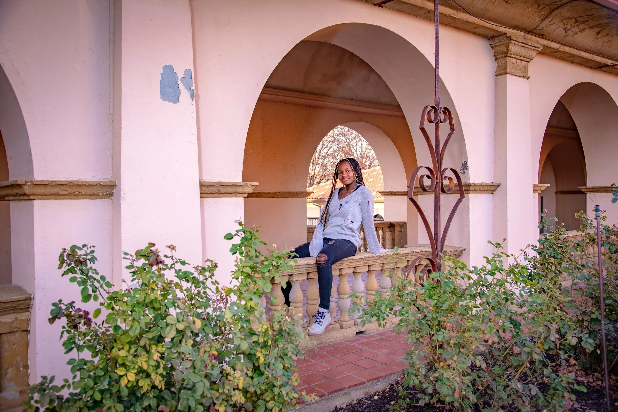 Senior girl posing on railing of archway