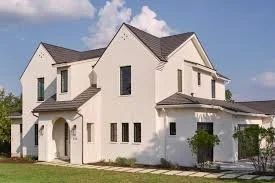 White two-story house with multiple gabled roofs and small front porch