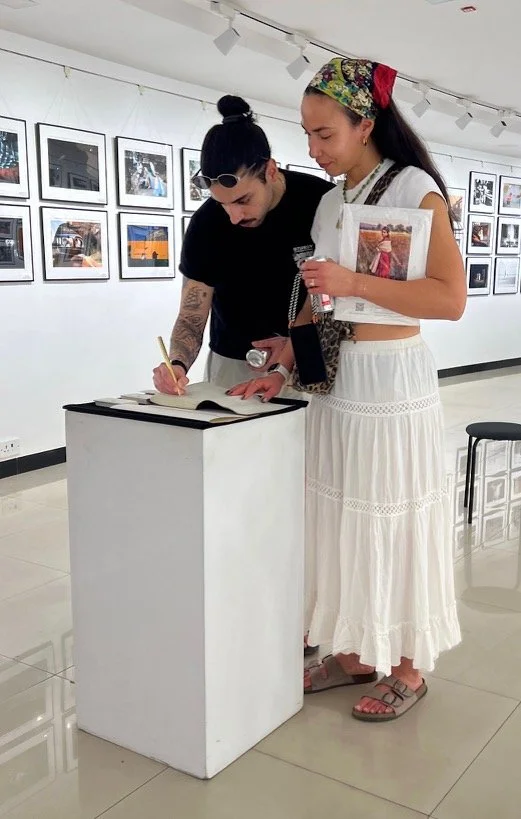 Visitor signing the guest book at the Pure Street Photography exhibition in Mumbai, India.