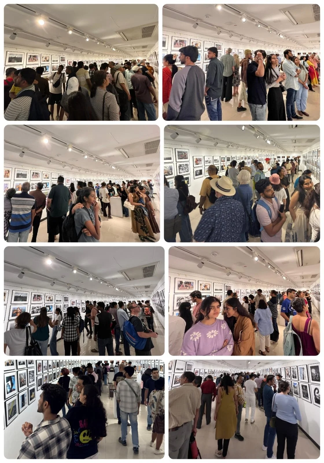 People viewing artwork in an art gallery or exhibition with framed photographs or paintings on white walls.