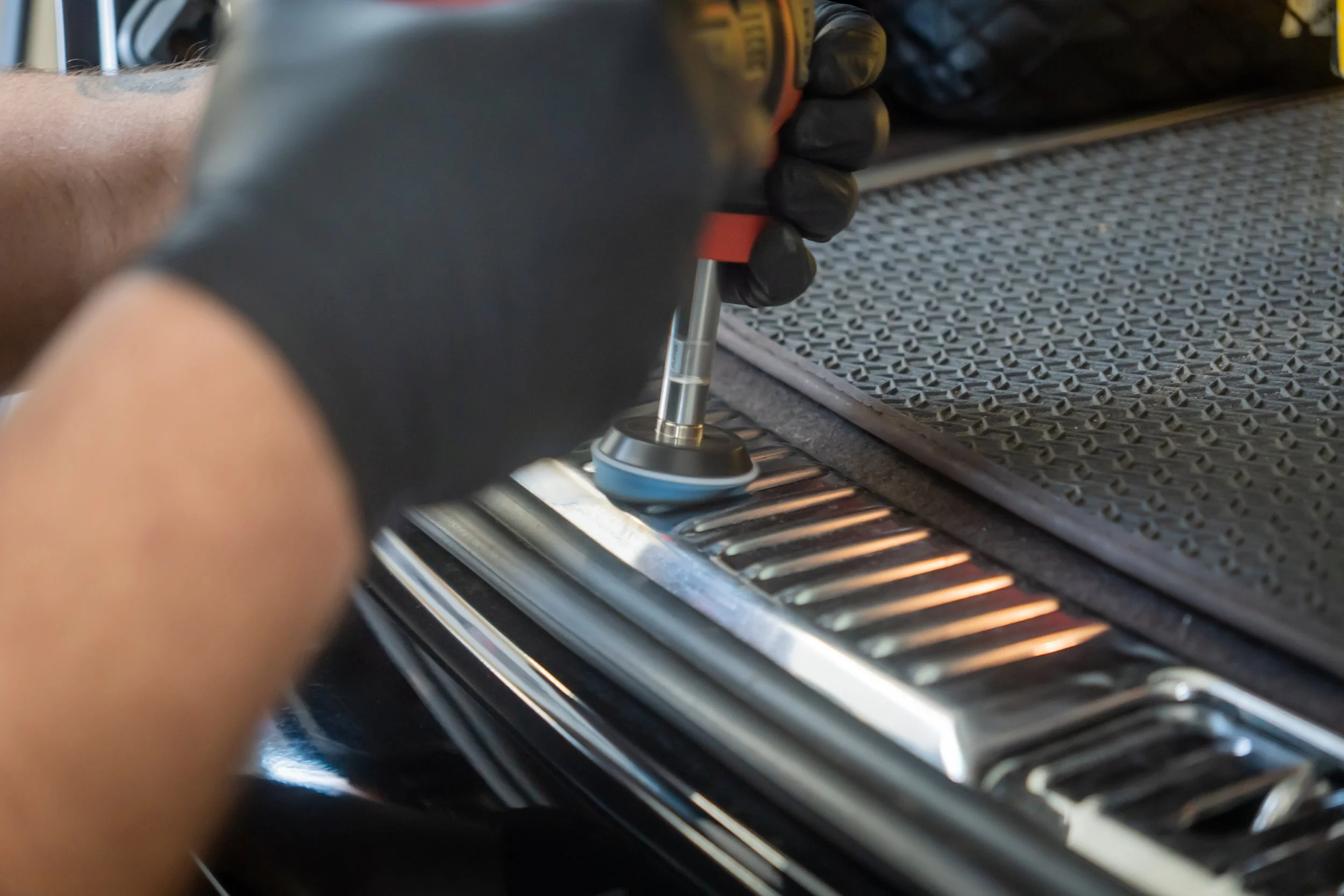 Person wechselt das Autotrennmatte mit einem Werkzeug in einem Auto.