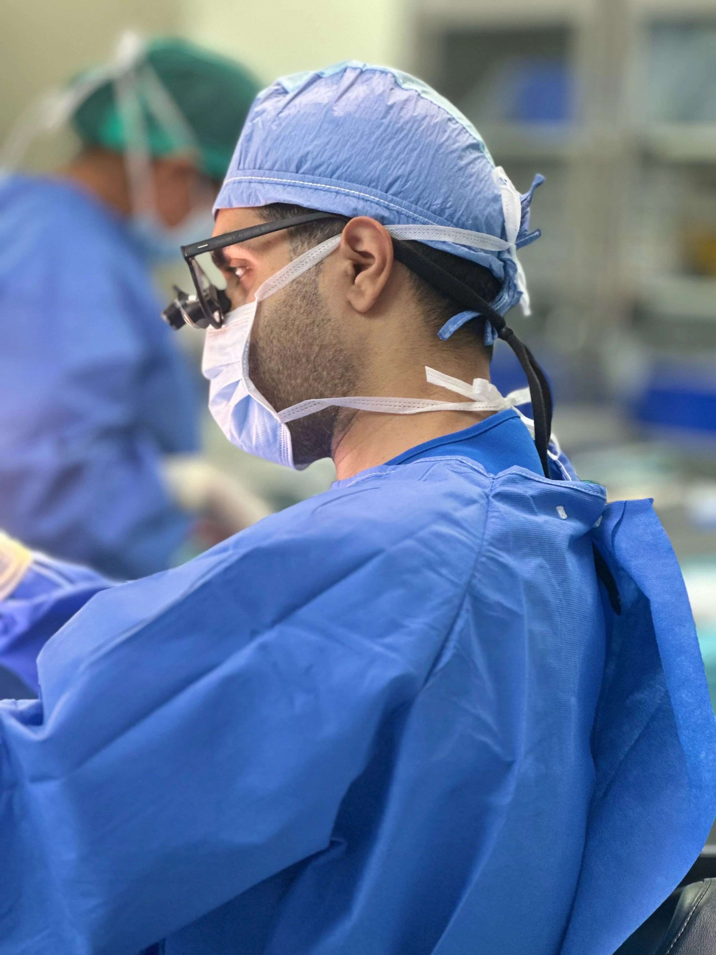 Medical professionals in scrubs and surgical masks preparing for an operation in a hospital setting.