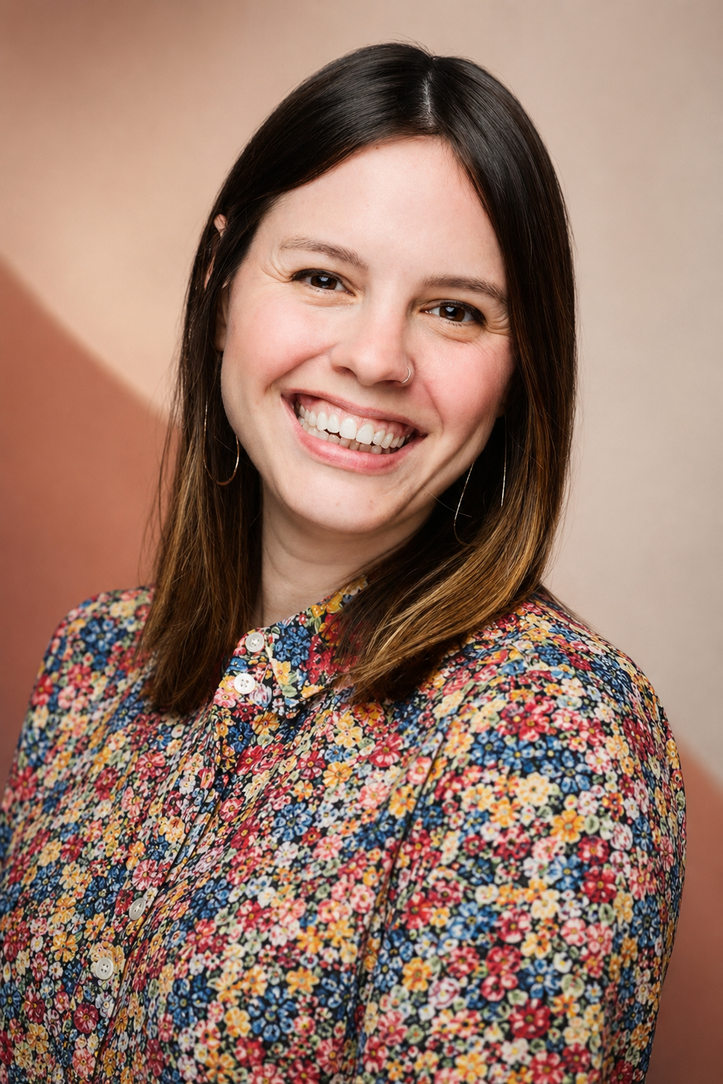 Nadine Peever, Founder and Managing Partner of Ember Consulting Group, smiling in a floral shirt