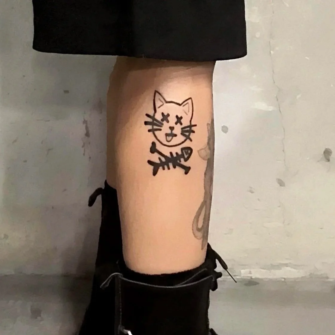 Tattoo of a graffiti and cartoon style cat in Black and Grey on a leg